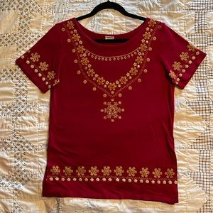 Red shirt with printed design and bead work on front. 6” side slits at hem